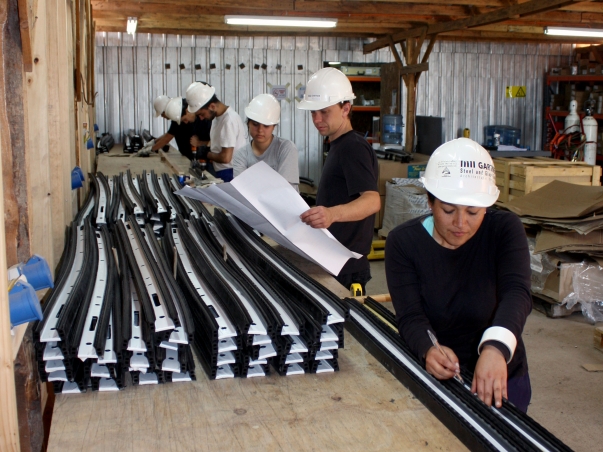 Nemzetközi önkéntesek a templom felépítménye elemeinek előkészítésében © Bahá'í Nemzetközi Hírszolgálat news.bahai.org